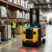 Automated forklift navigating safely through a warehouse environment.
