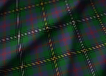 Dark green tartan plaid fabric with intersecting red, yellow, and thin white stripes; the classic check pattern feels bold and traditional.