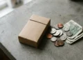 Unbranded cigarette pack on a counter next to US cash and coins