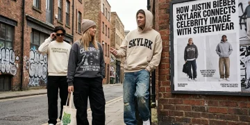 Streetwear-inspired photo of three people walking down a brick-paved alleyway past a poster titled "How Justin Bieber Skylark Connects Celebrity Image With Streetwear".