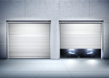 Two metal roll-up garage doors in a concrete wall; the left is closed, while the right is partly open with bright headlights glowing beneath, creating a sleek, dramatic mood.