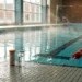 Pool test strips on the deck of an indoor swimming pool with humid air above the water